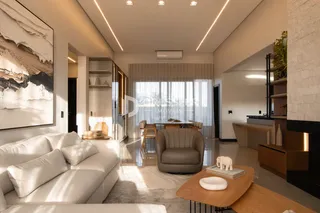 Sala de estar moderna com sofá branco e iluminação clara.