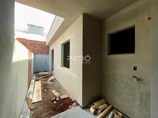 Interior de uma construção em Lajeado, Brasil, mostrando paredes de concreto e entulho no chão.