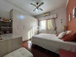 Quarto com armários embutidos e piso de madeira.