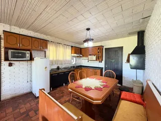 Foto de uma cozinha e sala de jantar com piso de terracota em uma residência.