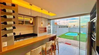 Vista da cozinha e sala de jantar com acesso a uma área externa com piscina.