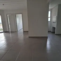 Hall de entrada com piso de cerâmica claro.