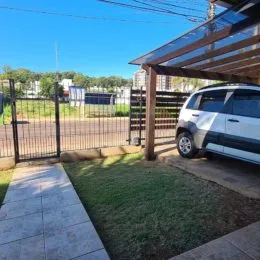 Área externa com gramado e estrutura de madeira em uma propriedade.