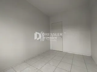 Parede branca de um cômodo com piso de cerâmica.