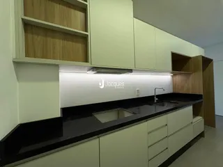 Foto de uma cozinha moderna com armários verdes e bancada escura.