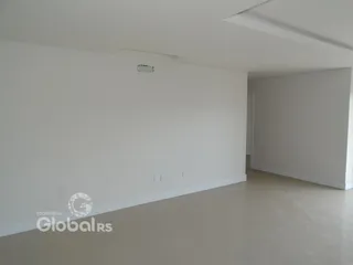 Interior de uma sala com paredes brancas e piso claro.