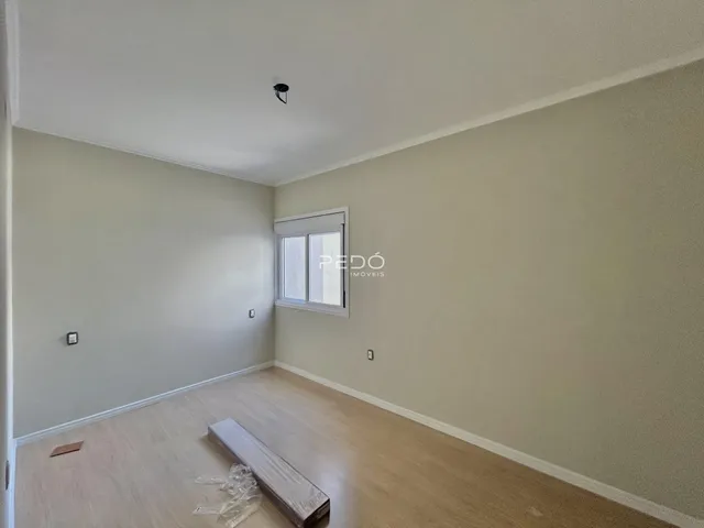 A sala apresenta paredes claras e piso de madeira clara.