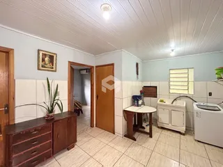 Foto interna de uma cozinha com piso de cerâmica e armários de madeira.