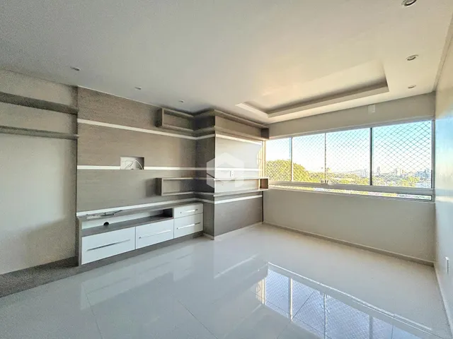 Sala de estar moderna com grandes janelas e piso claro.