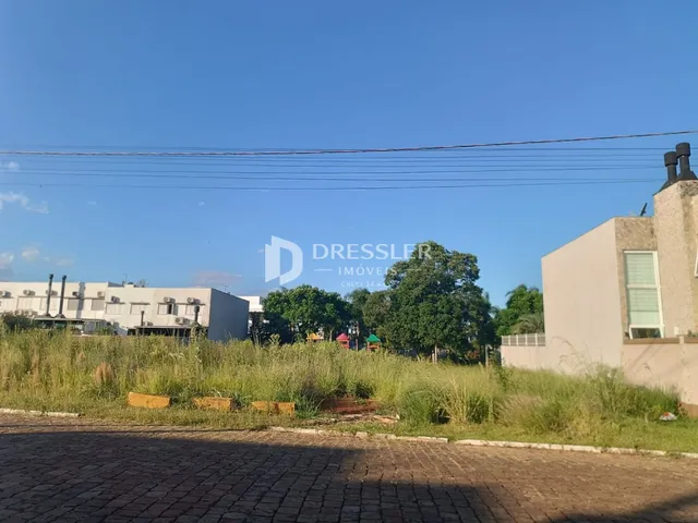 Vista externa da propriedade com grama alta e paisagem.