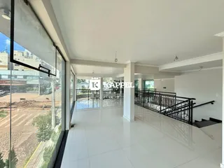Vista interna de um hall com piso claro e escadaria metálica em um imóvel em Lajeado.
