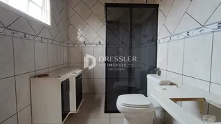 Foto de um banheiro com revestimento cerâmico e portas de vidro.