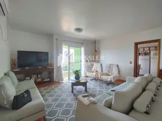 Sala de estar com sofá e televisão em um imóvel.