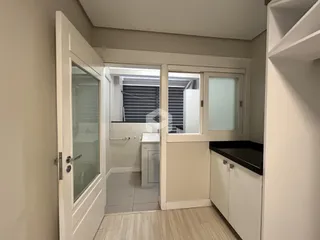 Vista de um corredor interno com acesso a um banheiro.