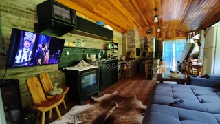 Sala de estar com piso de madeira e televisão montada na parede.