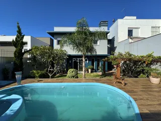 Vista externa de uma residência com piscina e deck em Lajeado.