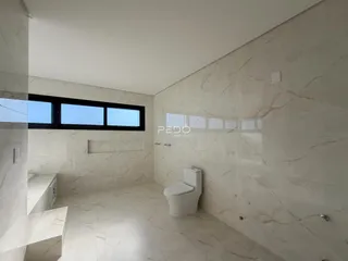 Um banheiro com revestimento em mármore claro e piso de porcelanato.