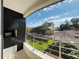 Vista da janela de um imóvel em Lajeado, Brasil, com grade de segurança e paisagem verde.