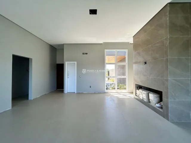 Ambiente interno amplo com paredes brancas e teto liso.