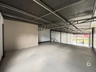 Espaço interno amplo com estrutura de metal exposta e piso liso.