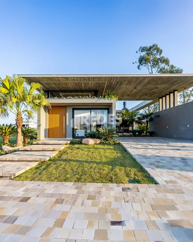 Fachada moderna de uma residência em Lajeado, Brasil, com paisagismo frontal.