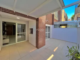 Sala de estar com portas de vidro que se abre para uma área externa.