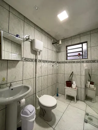 Foto de um banheiro interno com revestimento de cerâmica e louças sanitárias.