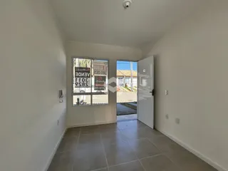 Hall de entrada com piso de cerâmica e paredes brancas.