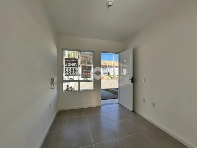 Hall de entrada com piso de cerâmica e paredes brancas.