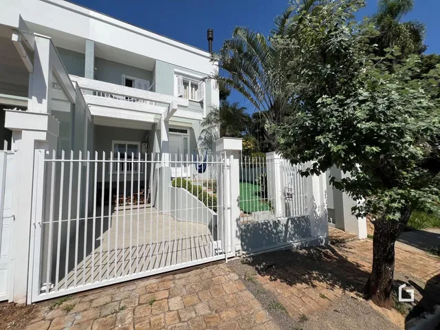 Fachada de uma residência em Lajeado, Brasil com cerca e portão branco.