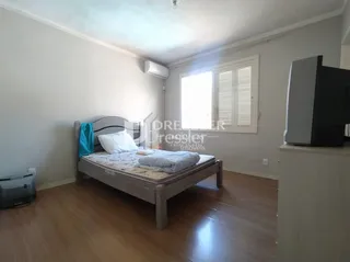 Quarto com cama de madeira e piso de madeira.