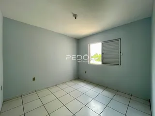 Uma sala interna com piso de cerâmica branca e paredes em tom azul claro.