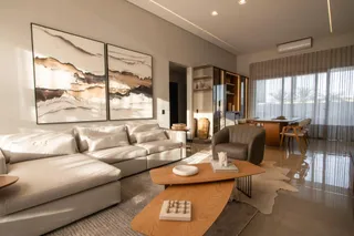 Sala de estar moderna com sofá grande e obras de arte em um apartamento em Lajeado.