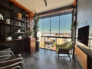 Sala de estar com estantes de madeira e vista para a cidade.