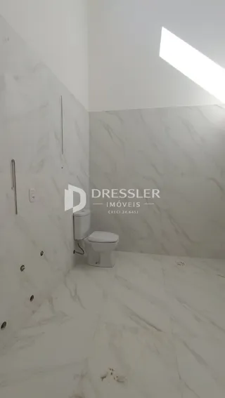 Foto de um banheiro com revestimento em mármore branco.