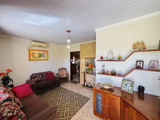 Sala de estar com sofá e piso de cerâmica em uma residência.