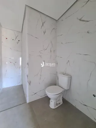 Foto de um banheiro com revestimento de mármore branco nas paredes.