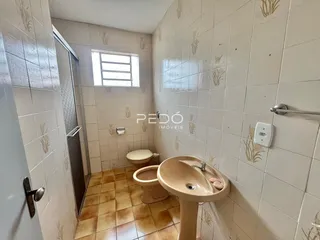 Interior de um banheiro com piso de cerâmica e azulejos brancos.