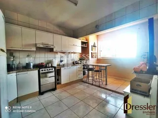 A cozinha apresenta armários brancos e piso de cerâmica.