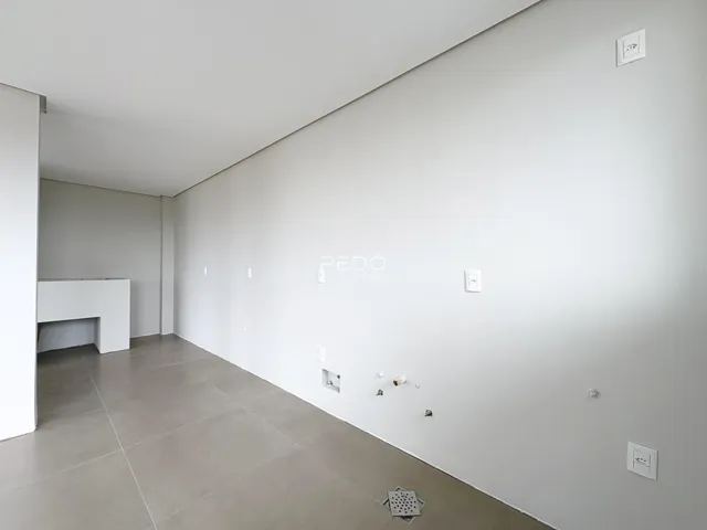 Foto de um cômodo interno com paredes brancas e piso de concreto.