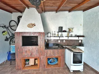 Sala com lareira de tijolos aparentes e teto de madeira.