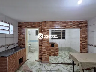 Interior de uma área comum com paredes de tijolos aparentes e piso de cerâmica.