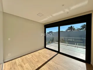 Ambiente interno com piso de madeira e porta de vidro voltada para o exterior.