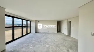 Vista interna de um ambiente com piso de concreto e grandes janelas em uma propriedade em Lajeado.