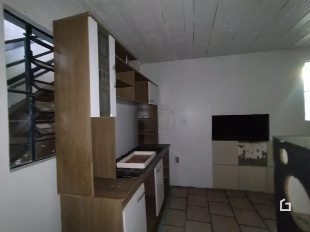 Interior de uma sala com painéis de madeira e piso cerâmico.