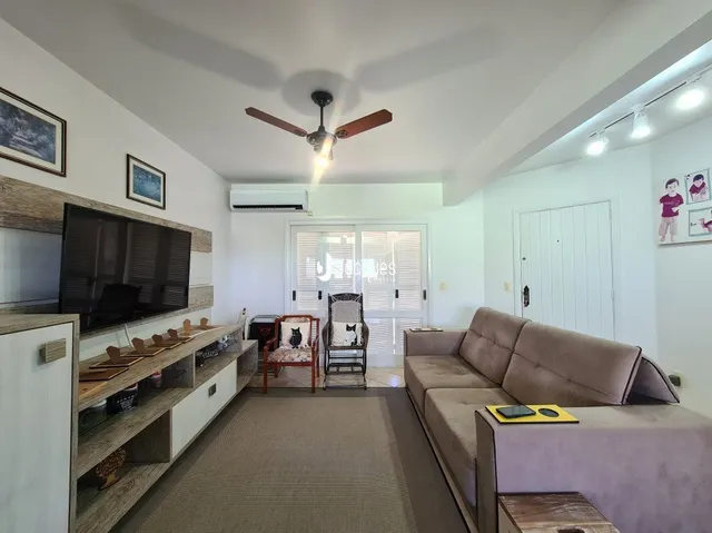 Sala de estar com sofá e televisão em um imóvel no Brasil.