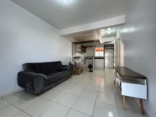 Sala de estar com sofá e piso de cerâmica clara.
