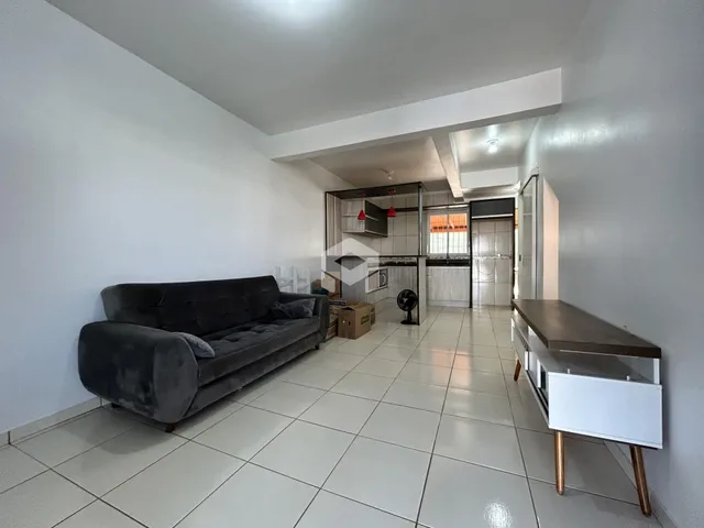 Sala de estar com sofá e piso de cerâmica clara.