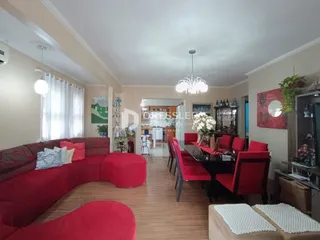 Sala de estar com sofá vermelho e mesa de jantar em um imóvel no Brasil.