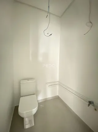 Foto de um banheiro interno com piso claro e azulejos brancos.